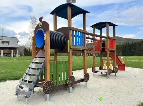 a playground with a slide and a play structure at Szent Orbán Erdei Wellness Hotel in Kóspallag