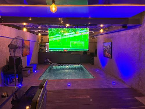 - une piscine avec une télévision dans l'établissement Riivana Tavern, à Lekki
