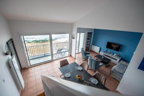 Il comprend un salon avec une table à manger et un balcon. dans l'établissement MAT DE MISAINE - Face Mer, à Les Sables-dʼOlonne