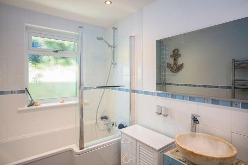 uma casa de banho com um lavatório, um chuveiro e uma banheira em Fairwinds,Bigbury on sea ,Three-bed Beach House em Bigbury on Sea