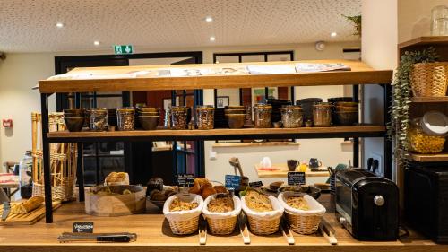 a shelf filled with lots of baskets of food at Hôtel Vauban in Le Palais