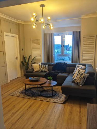 a living room with a couch and a table at Sweeney Stays, Cadzow Apartment in Hamilton