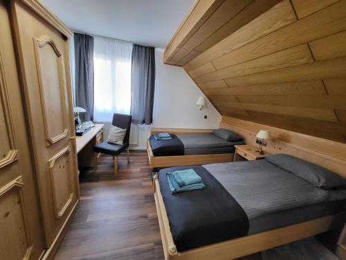a hotel room with two beds and a desk at Bergischer Hof - Bergischer Hofgarten in Windeck