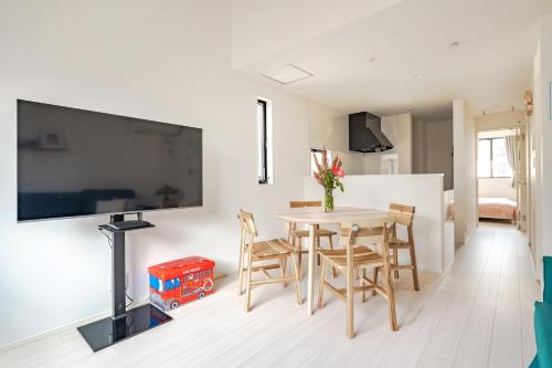 a living room with a table and chairs and a tv at SKYTREE HOUSE in Tokyo