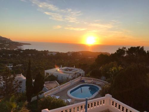 a sunset over a villa with a swimming pool at Sophisticated Villa in Sant Josep de sa Talaia with Private Pool in Sant Josep de Sa Talaia