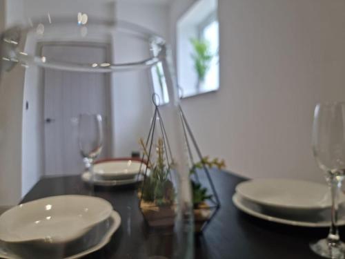 einen Tisch mit zwei weißen Tellern und Gläsern darauf in der Unterkunft Beautiful and Spacious 2-Bed Apartment: Home Away From Home in South Benfleet