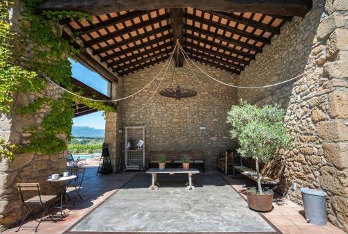 un patio con un banco en un edificio de piedra en Villa privada de lujo Can Riera, en Pujals dels Cavallers
