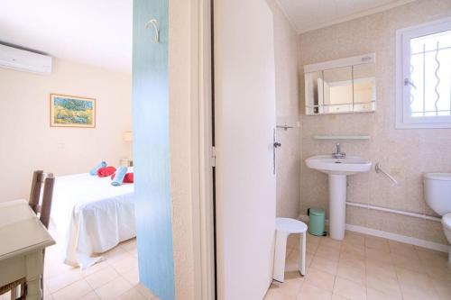 La salle de bains est pourvue d'un lavabo et d'un lit dans la chambre. dans l'établissement Villa les lauriers - domaine des lauriers by Halldis, à Valbonne