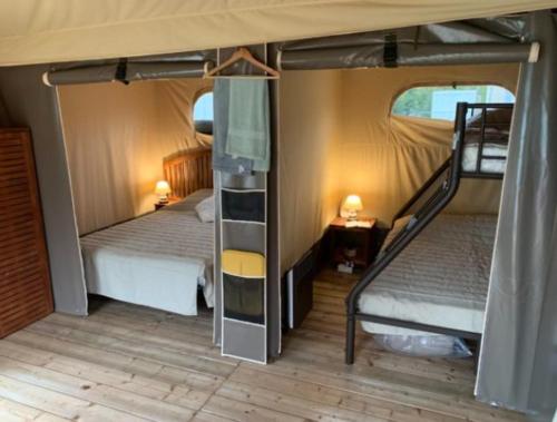 Zimmer mit 2 Etagenbetten und einer Treppe in der Unterkunft Camping L'oasis Du Berry in Saint-Gaultier