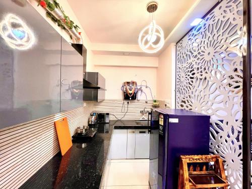 une cuisine avec des murs noirs et blancs et un comptoir dans l'établissement Airport Bliss Apartment+Balcony & Netflix + Prime, à Jaipur