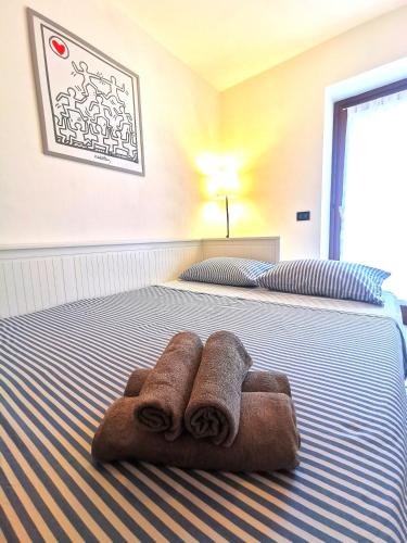 a bed with two towels sitting on top of it at Old Town Apartment with Terrace - Live Love Lake in Peschiera del Garda