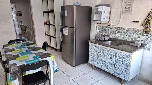 a kitchen with a sink and a refrigerator at Hospedagem Camisa 10 in Santos