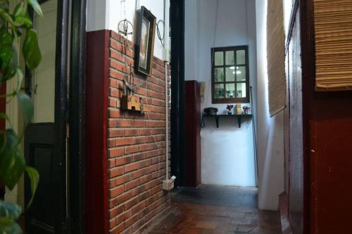 un pasillo con una pared de ladrillo y una puerta roja en Encanto Porteño en Buenos Aires