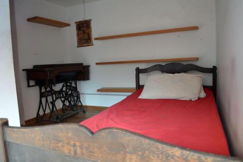 1 dormitorio con 1 cama con manta roja y piano en Encanto Porteño en Buenos Aires