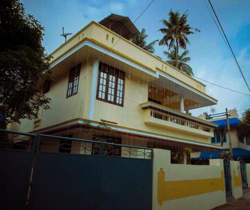 un bâtiment avec une clôture bleue devant lui dans l'établissement Urban Haven Short Stays, à Trivandrum