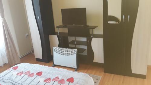 a room with a desk and a bed and a table at Casa Ovi și Simo in Haţeg