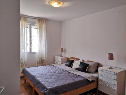 a bedroom with a bed and a dresser and a window at Leda in Pula