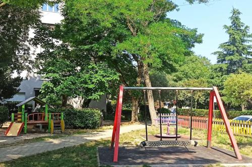 a playground with colorful swings in a park at Leda in Pula