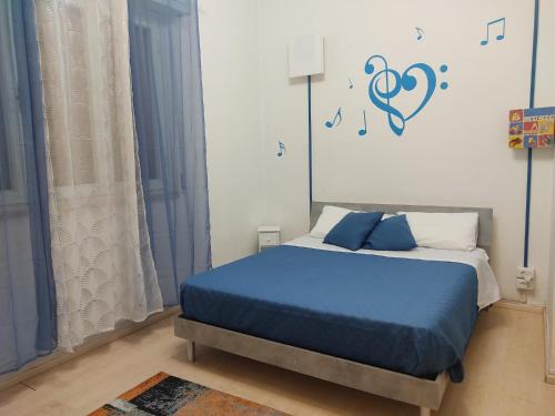 a bedroom with a bed with blue sheets and music notes on the wall at Casa Vacanze Ale e Gio in Piombino