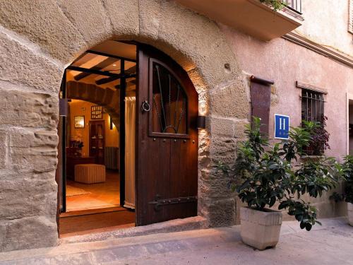 una entrada a un edificio con puerta de madera en El Lagar del Vero en Huerta de Vero