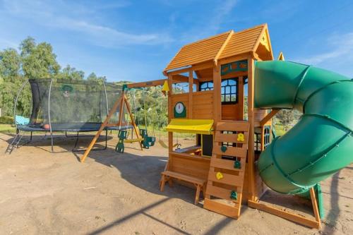 a playground with a slide and a swing at Harley Davidson Ranch Glampling With Kids Play Zone in Ramona