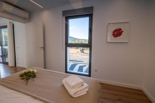 una stanza con un letto con finestra e asciugamani di Casa Rural Espadan Suites ad Artana