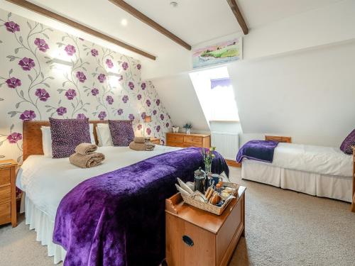 a bedroom with two beds with purple sheets at Nobles Cottage - Uk43351 in Whitby