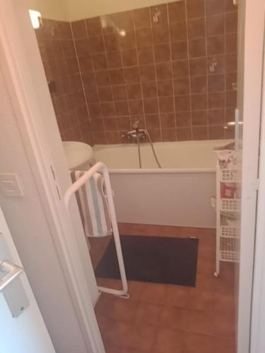 La salle de bains est pourvue d'une baignoire et d'une chaise. dans l'établissement Mer et Soleil, à Saint-Raphaël