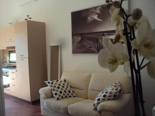 een woonkamer met een bank en een vaas met bloemen bij DEPANDANCE CON PISCINA IN VILLA VICINO PORTO CESAREO in Copertino