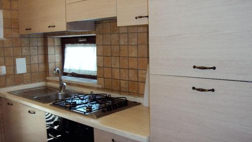 uma cozinha com um lavatório e um fogão forno superior em DEPANDANCE CON PISCINA IN VILLA VICINO PORTO CESAREO em Copertino