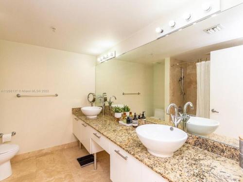 a bathroom with two sinks and a large mirror at Beautiful Brickell Loft with Free Parking in Miami