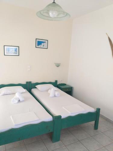two beds in a room with white walls at Panoramic View in Agios Prokopios