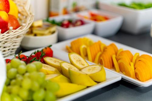 a plate of fruit on a table with grapes at Wczasowa 8 Apartments in Sarbinowo