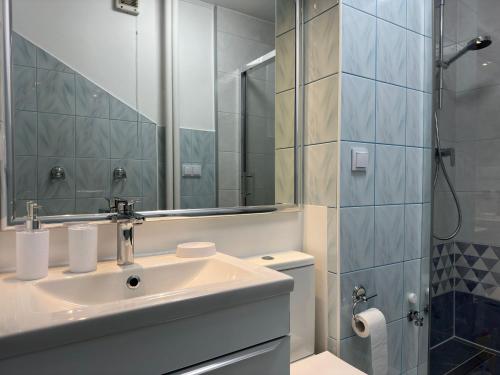 a bathroom with a sink and a shower at Apartament Bazyliańska - 100m do Metra "Bródno", 20 minut do centrum Warszawy in Warsaw