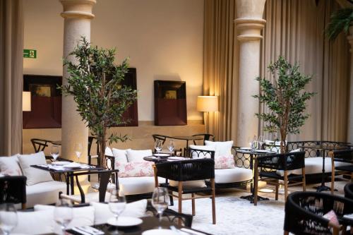 a restaurant with tables and chairs in a room at Hotel Cetina Palacio de los Salcedo in Baeza