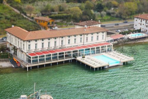 a building with a dock in the water at Araba Fenice Hotel in Iseo