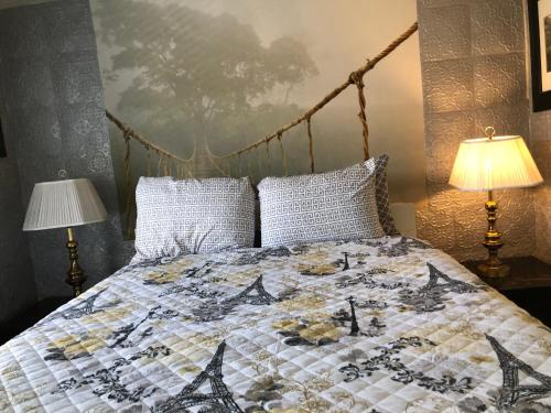 a bed with a quilt on it with two lamps at Highland Park Pittsburgh in Pittsburgh