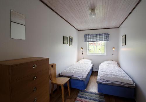 a bedroom with two beds and a dresser and a window at STF Tivedstorp in Tivedstorp