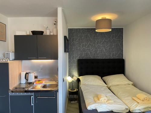 Bett in einem kleinen Zimmer mit Küche in der Unterkunft Apartment Pistenräuber in Winterberg