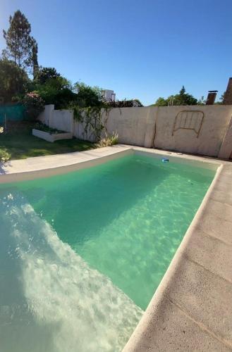 a swimming pool with green water in a yard at Casa en las sierras in Río Ceballos