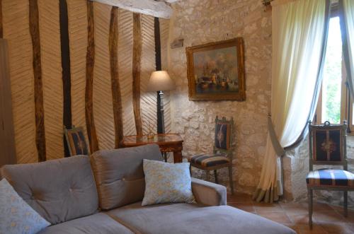 a living room with a couch and a table at Le Murmure des Fées in Issigeac