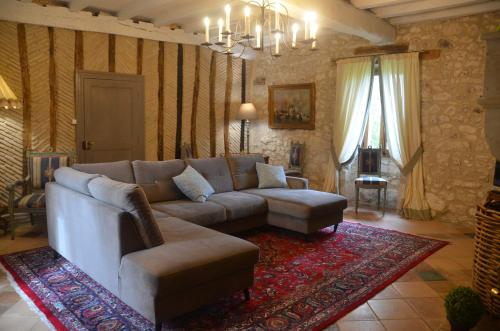 a living room with a couch and a rug at Le Murmure des Fées in Issigeac