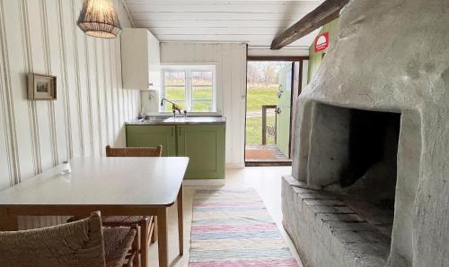 a kitchen with a table and a stone fireplace at STF Tivedstorp in Tivedstorp