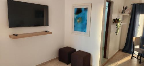 a living room with a flat screen tv on a wall at Ocean Village at Combate in Cabo Rojo