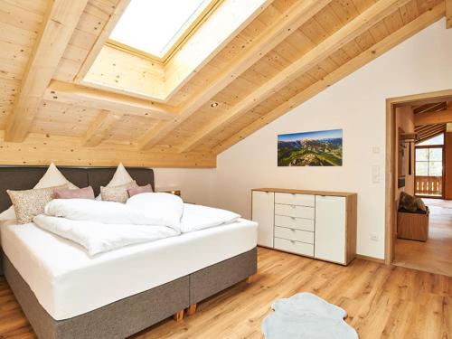 Un dormitorio con una cama grande en una habitación con techos de madera. en Krennlehen, en Schönau am Königssee