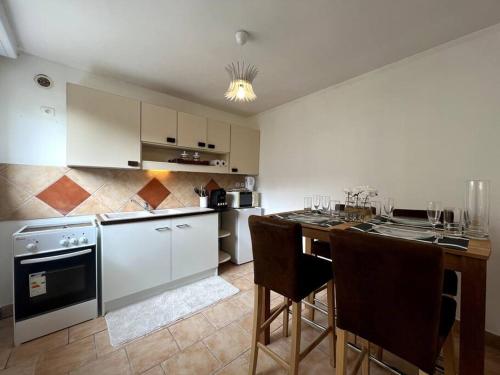 una cocina con armarios blancos y una mesa con sillas. en Vaugirard - 4 pers Terrasse, en Montereau-Fault-Yonne