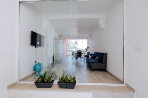 a living room with glass walls and plants at Maison Lorelle Sorrento in Sorrento