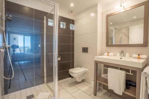 La salle de bains est pourvue d'une douche, de toilettes et d'un lavabo. dans l'établissement Hotel Le Grand Pavois, au Lavandou