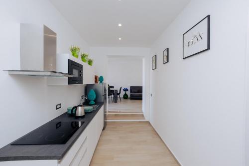 a kitchen with white walls and black counter tops at Maison Lorelle - De Vivo Realty Sorrento in Sorrento