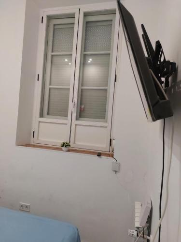 ventana en una habitación blanca con TV en Habitación en Madrid, en Madrid